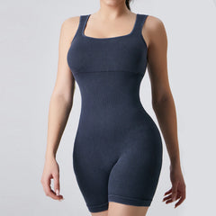 Navy blue shapewear bodysuit worn by a model on a light gray background