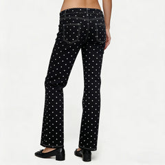 Black jeans with white polka dots worn by a person on a white background