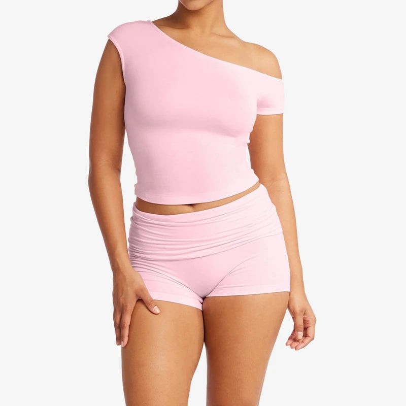 Women's light pink solid crop top and matching shorts set with off-shoulder top and ruched details.

