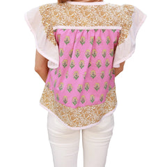 Back view of a person wearing a floral and pink patterned top with white pants 