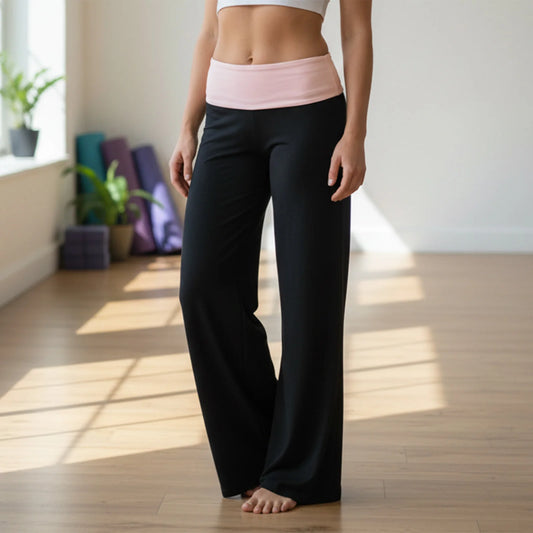 Person wearing black yoga pants and a pink top in a bright room with plants.