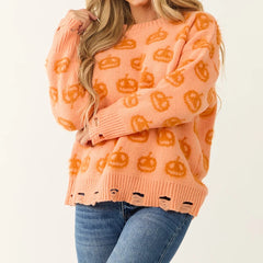 Person wearing an orange sweater with pumpkin patterns 