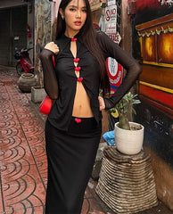 A woman wearing a black mesh top and maxi skirt set, showcasing the flattering silhouette and comfortable fit.