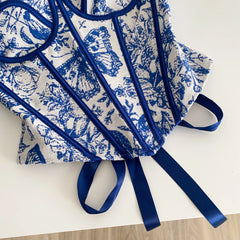Blue and white patterned apron with long straps on a light background