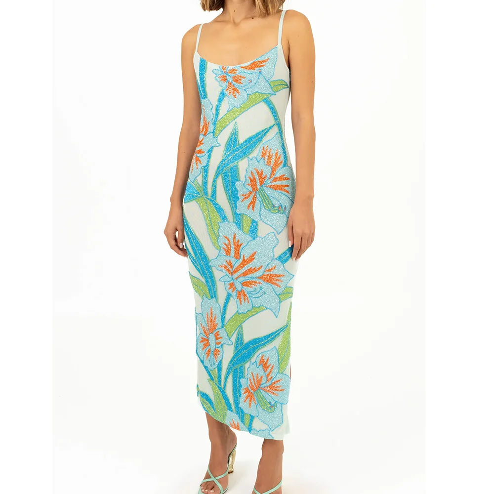 Woman wearing a floral dress with blue, orange, and green patterns 