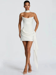 Woman wearing a white strapless dress with a draped design 