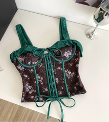 Floral crop top with green straps on a white surface