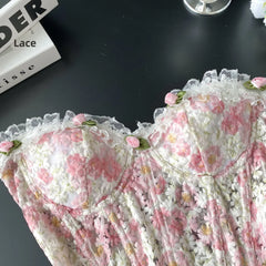 Floral lace fabric with pink flowers on a dark surface