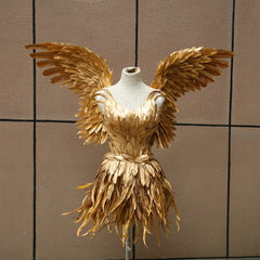 Gold feathered dress on a mannequin against a tiled wall.