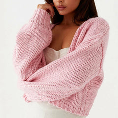 Woman wearing a pink knitted cardigan on a white background