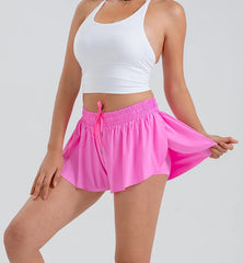 Person wearing a white tank top and pink athletic skirt full view