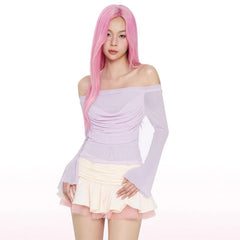 Person wearing a light purple off-shoulder top and white skirt with pink hair