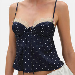 Navy blue polka dot top with lace details on a plain background