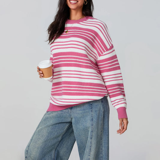 Woman wearing a pink and white striped sweater holding a coffee cup on a gray background