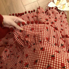 Women's red strawberry print tassel long skirt with tiered ruffles.

