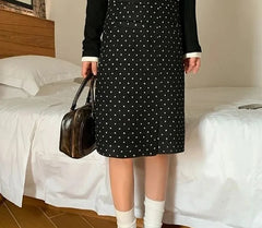 A woman wearing a stylish polka dot midi skirt, showing off its flattering fit and playful design.