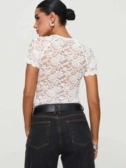 Woman wearing a white lace top and black jeans - back view