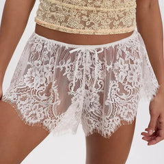 White lace shorts worn by a person on a plain background