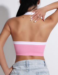 Person wearing a pink and white bandeau top with light blue jeans- back view