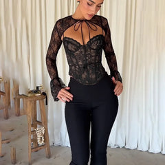 A woman wearing a black lace-up corset top with high-waisted jeans, showcasing its versatility and edgy style.