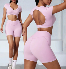 Woman wearing a pink athletic outfit with cut-out design on a light gray background