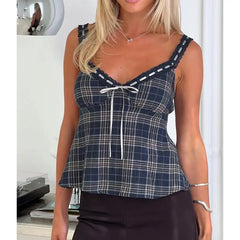 Woman wearing a blue plaid top with white trim indoors.