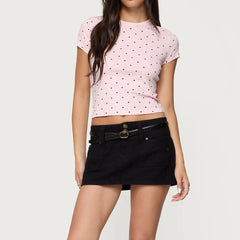 Person wearing a pink polka dot crop top and black skirt 