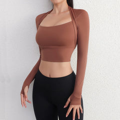 Person wearing a brown long-sleeve crop top and black leggings- full view