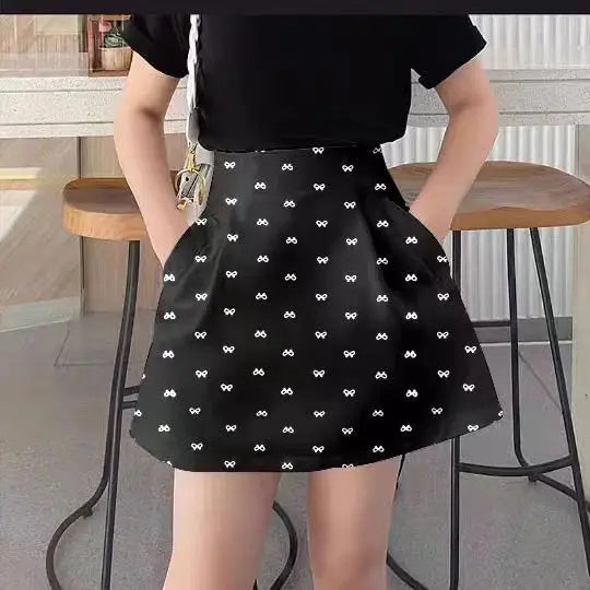 Person wearing a black skirt with white patterns in an indoor setting