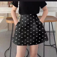 Person wearing a black skirt with white patterns in an indoor setting