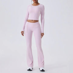 Pink athletic outfit with long-sleeve top and open-back design, shown from front 