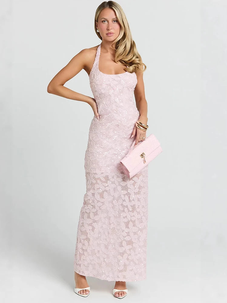 Close-up of a woman's hand resting on her hip, showcasing a light pink sequin halter maxi dress and gold bangles.