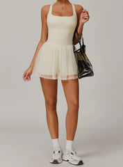 Person wearing a white dress with a black handbag- full view