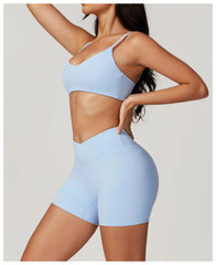 Person wearing a light blue sports bra and shorts set side view