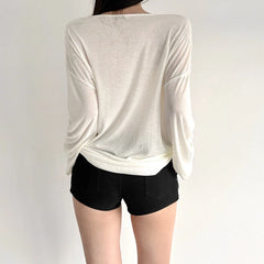 Person wearing a white long-sleeve top and black shorts