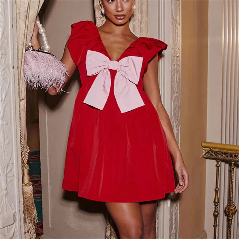 Woman wearing a red dress with a large bow in an elegant interior setting