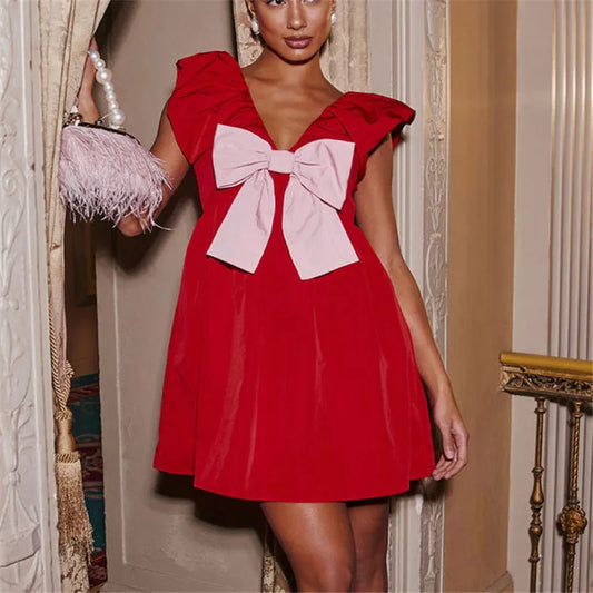 Woman wearing a red dress with a large bow in an elegant interior setting