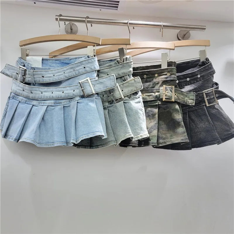 Three denim skirts with belts on hangers against a white background