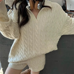 Model wearing a cream cable knit sweater with a polo collar and matching shorts.