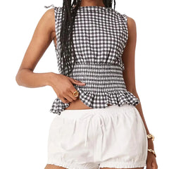 Person wearing a black and white checkered top and white shorts 