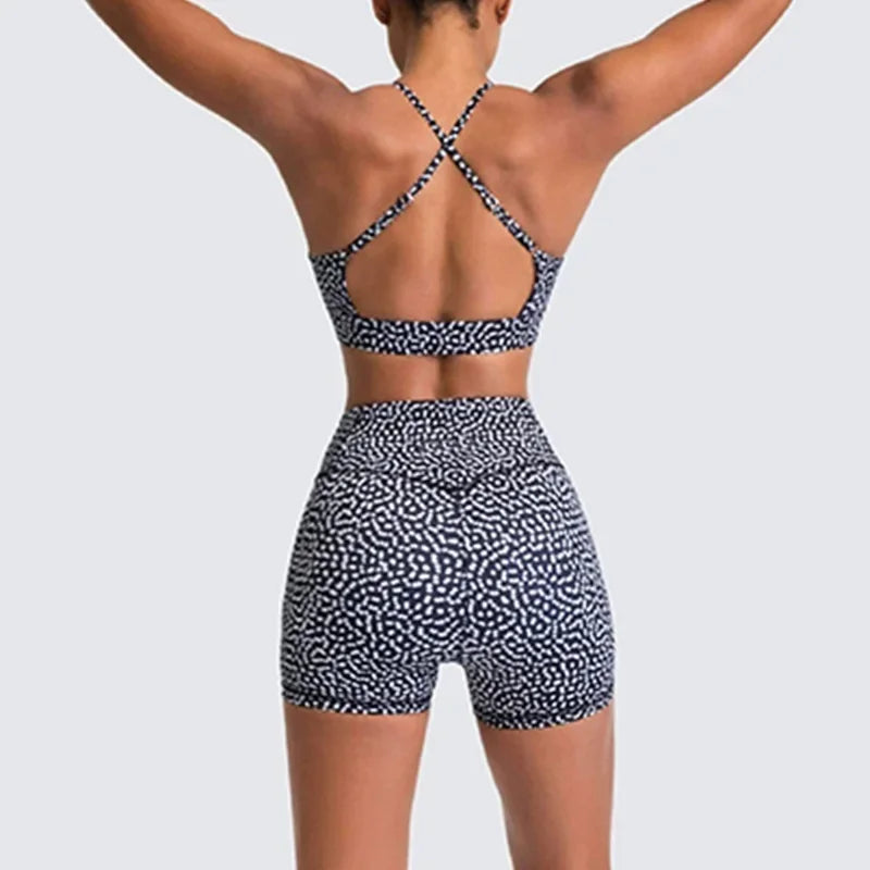Person wearing a black and white patterned sports bra and shorts on a light gray background