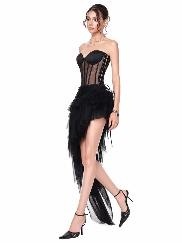 Woman wearing a black strapless dress with sheer overlay and feathered skirt 