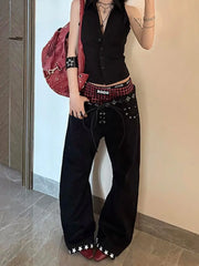 Person wearing a black outfit with plaid accents, standing against a beige wall.