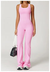 Person wearing a pink jumpsuit holding a black and white bag on a light gray background