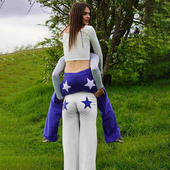 Woman wearing a pair of comfortable bootcut sweatpants with a unique back star patchwork design.