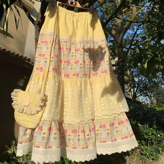 Women's yellow floral print patchwork lace maxi skirt with A-line silhouette.

