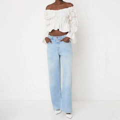 Person wearing a white off-shoulder top and light blue jeans 