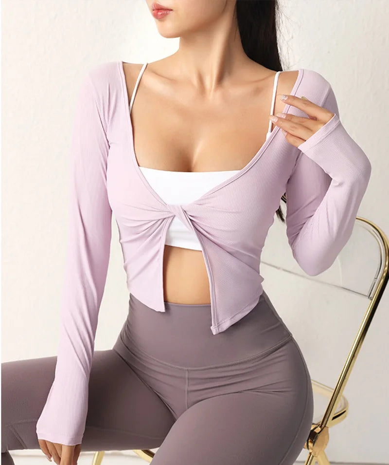 Person wearing a light purple cardigan over a white top and gray leggings