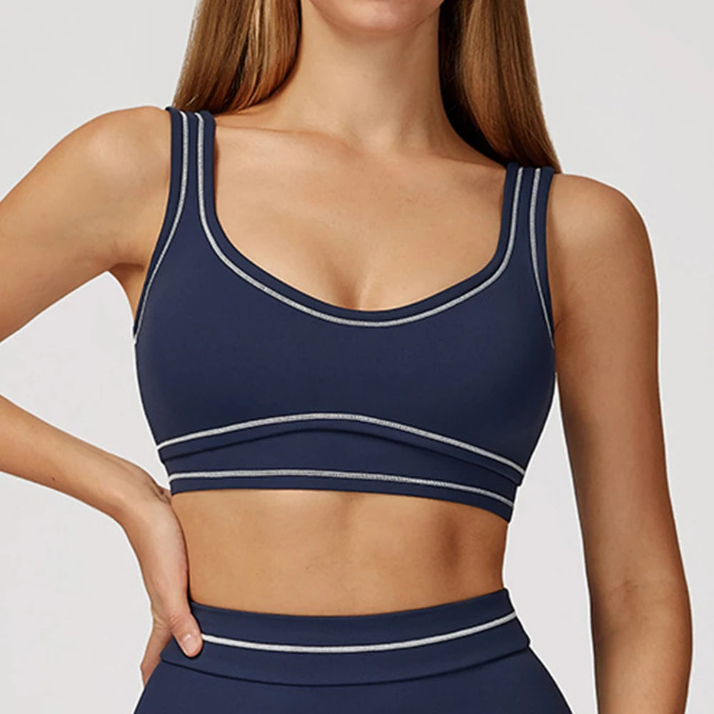 Navy sports bra with white accents worn by a model 