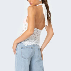 Woman wearing a white lace top and light blue jeans 